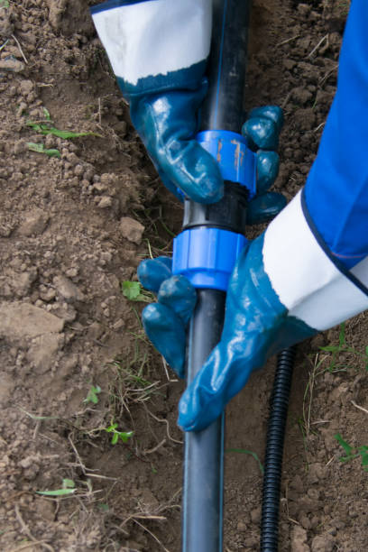 istock a worker is laying in a dug trench, a drain pipe 1159182133