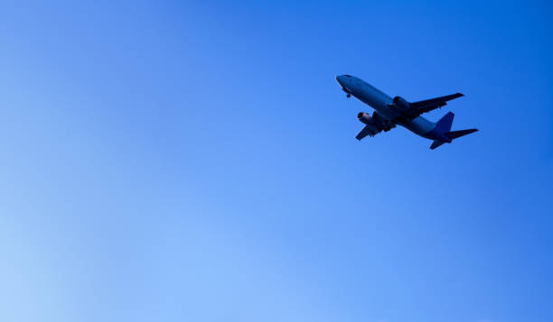 istock flying commercial passenger airplane over sunny blue sky 1159182989