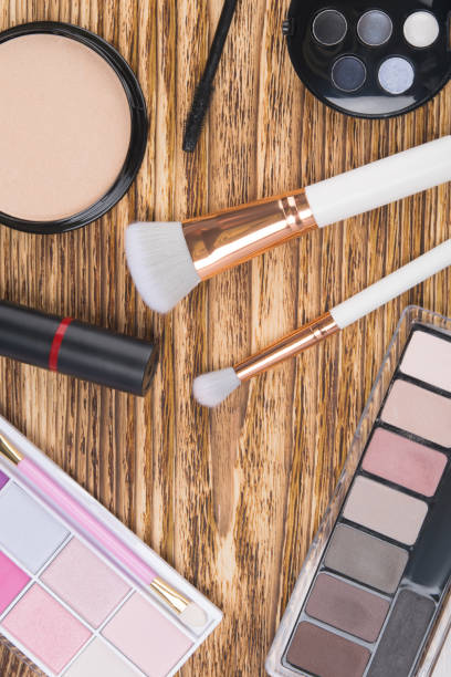 istock on a dark wooden background, items for makeup, brushes, powder, colored shadows, lipstick and mascara 1159183367