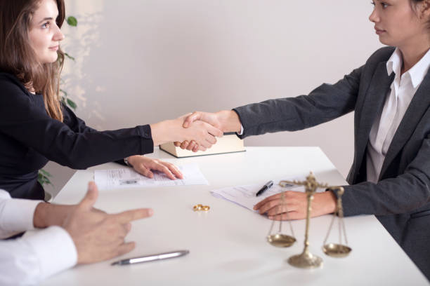 View of lawyer and client sitting at a table with the divorce decree and wedding rings partial view of lawyer and client sitting at a table with the divorce decree and wedding rings Dealing With Creditors stock pictures, royalty-free photos & images.