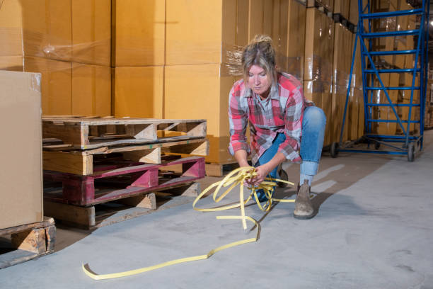 istock A female warehouse worker cleaning-up a safety hazard. 1159187837