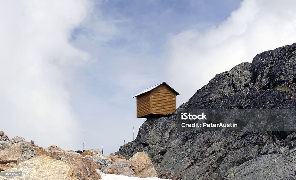Little House on the Precipice - Blue Sky Thinking This little shed was perched precariously near the summit of Whistler mountain, British Columbia, Canada. House Stock Photo