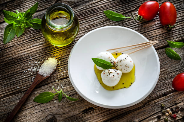 cuisine italienne: mozzarella bocconcini apéritif sur table rustique en bois - mozzarella caprese salad tomato italian cuisine photos et images de collection