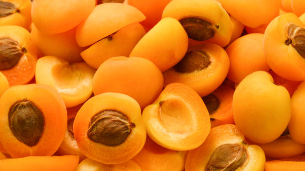 istock Ripe juicy orange apricots slices fruit background. 1159191962