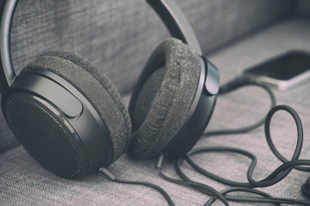 istock Headphones with smartphone on a couch 1159193628