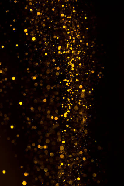 istock Glitter dust gold particles dark background 1159194461