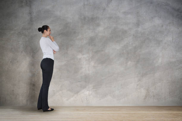 istock Young woman looking at the wall with space for your text or image. thinking and analysing idea. 1159194614