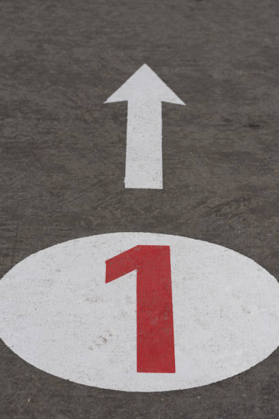 Number 1 one and arrow painted on concrete road