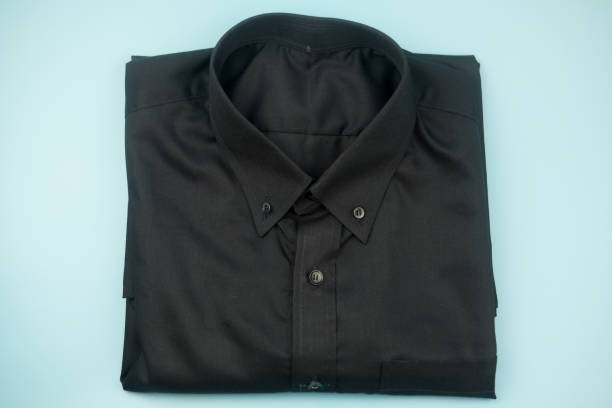 istock Black folded shirt on blue background. Top view 1159196228