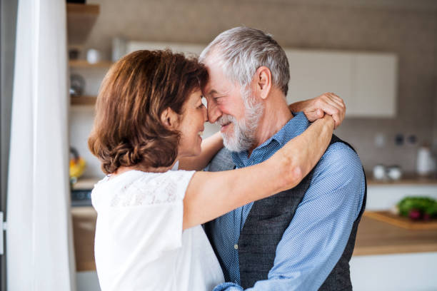 istock Affectionate senior couple in love standing indoors at home, hugging. 1159196614