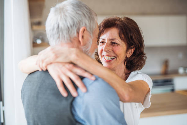 istock Affectionate senior couple in love standing indoors at home, hugging. 1159197170