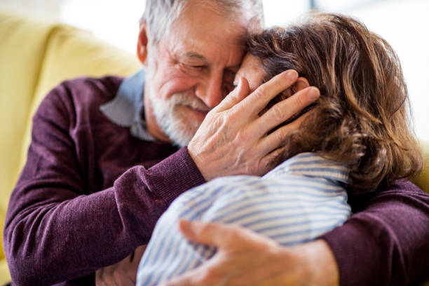 istock Affectionate senior couple in love sitting on sofa indoors at home, hugging. 1159197209