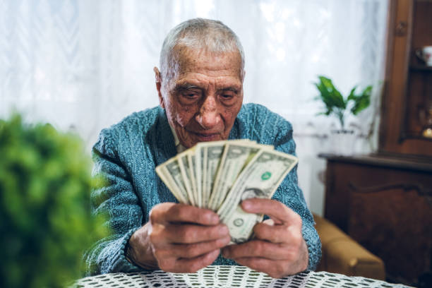 istock Senior man holding savings 1159197213