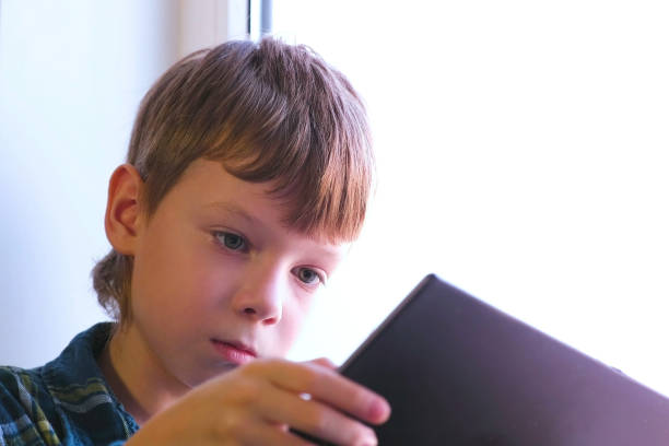 istock Seroisly boy is watching a video in tablet. 1159197764