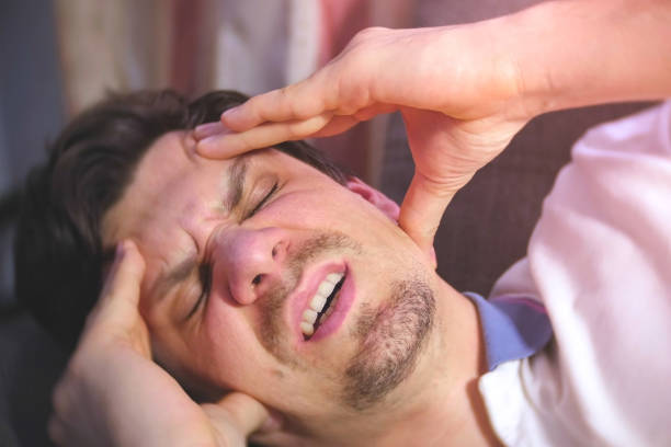 istock Young man with a headache lying on the couch. 1159197880