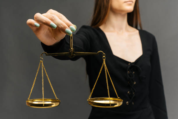 istock Serious woman holding the justice scale on dark background 1159198582