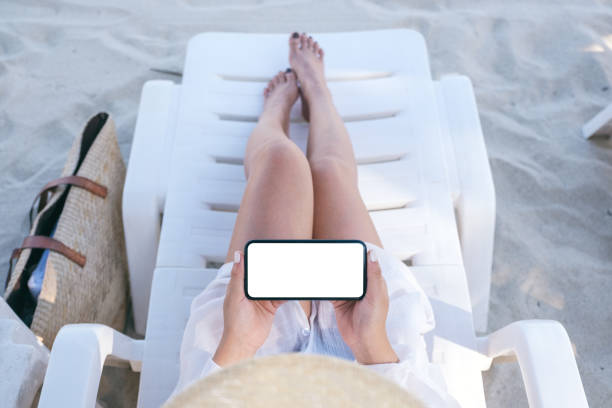 istock a woman's hand holding white mobile phone with blank desktop screen 1159199996