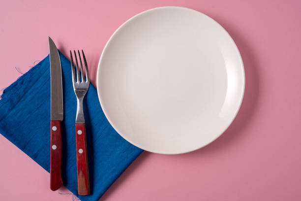 istock Food background with empty white plate and cutlery , over pink background, flat lay. 1159200097
