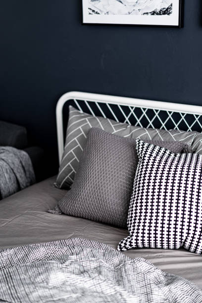 istock Bedroom corner setting with comfortable graphic pillows in neutral color with navy blue painted wall/ comfortable interior / interior design / relax mood 1159201480