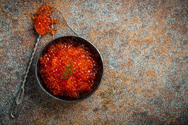 istock Delicious red caviar in black bowl on a dark concrete background. Top view with copy space. Flat lay 1159202876