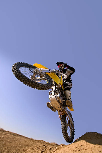 Motocross Rider Jumping Against Blue Sky stock photo