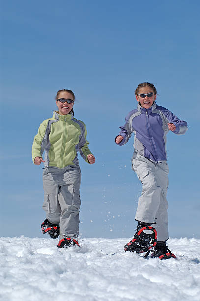 enfants marche en raquettes contre ciel bleu - winter snowshoeing running snowshoe photos et images de collection