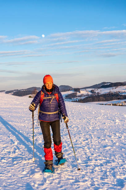 schneeschuhschuhbei sonnenuntergang - snowshoeing snowshoe women shoe stock-fotos und bilder