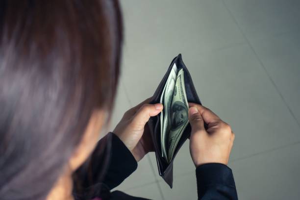 istock woman taking out money dollar banknotes from wallet 1159207330