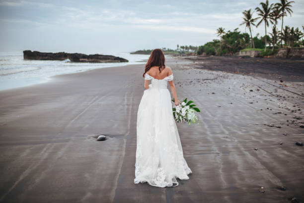 istock Bride on a beach in the blue water 1159211074