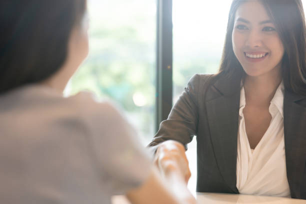 portrait young asian woman interviewer and interviewee shaking hands for a job interview .business people handshake in modern office. greeting deal concept - gesturing interview business sitting imagens e fotografias de stock