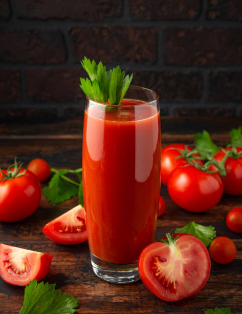 istock Tomato juice in glass with celery on rustic wooden table 1159212895