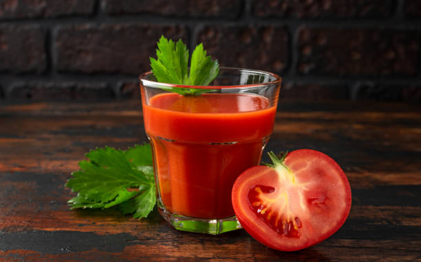 istock Tomato juice in glass with celery on rustic wooden table 1159212933