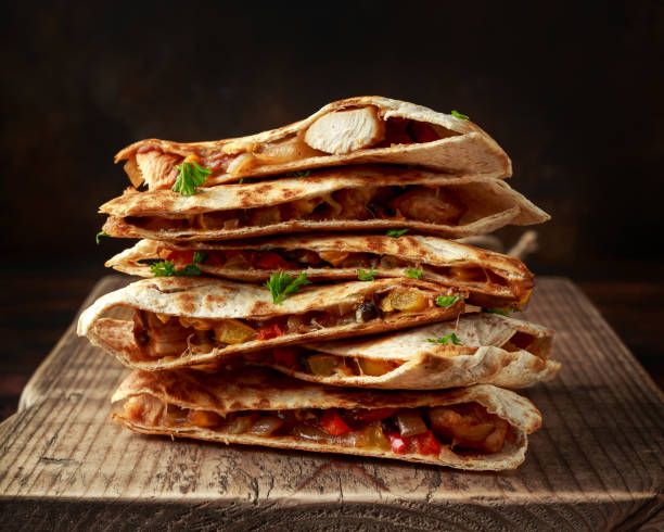 istock Mexican quesadilla stack with chicken, corn, black beans, cheese, vegetables on wooden board 1159212990