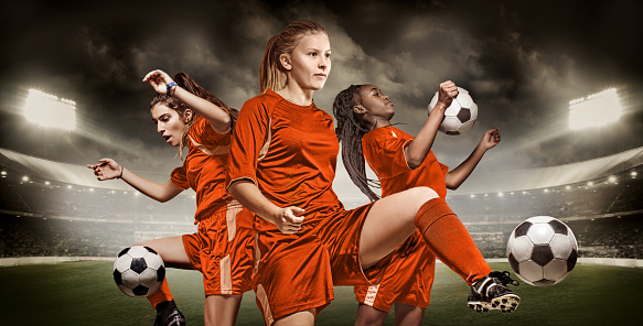 Three mixed race Dutch Female Football Players controlling Soccer Balls in front of Stadium Lights