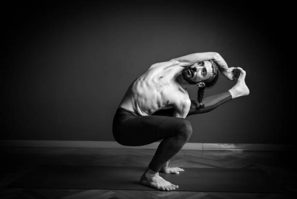istock Man doing one leg squat pose in yoga 1159213873