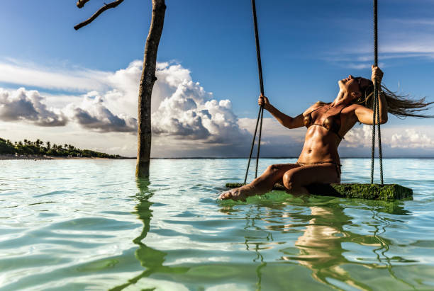 istock Sensual woman having fun on a swing at sea. 1159217871