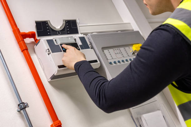Male Technician Checking Smoke Detector In Datacenter Midsection of male technician checking smoke detector in server room at datacenter fire inspection stock pictures, royalty-free photos & images