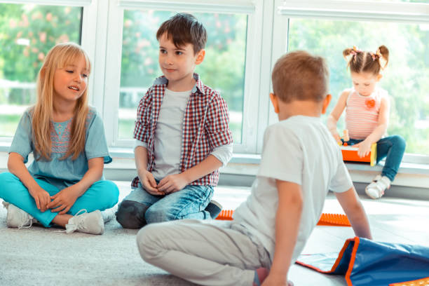 istock Nice pretty children sitting on the floor 1159219872