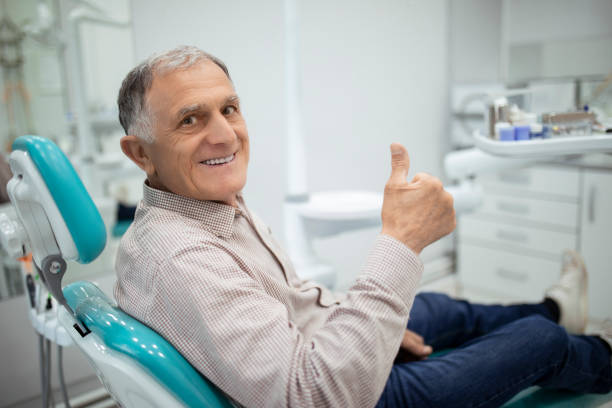 vecchio anziano seduto su una sedia dentale - dentist dental hygiene smiling patient foto e immagini stock