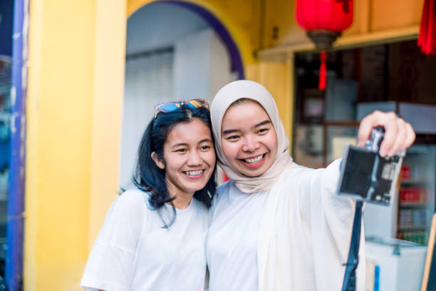 istock Young Two Beautiful Women Taking Photo Together using Digital Camera While Travelling 1159224391