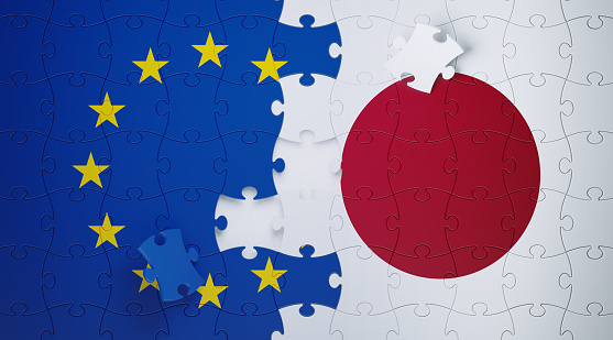 Jigsaw puzzle pieces textured with European Union and Japanese flags. Horizontal composition with copy space. Solution concept.