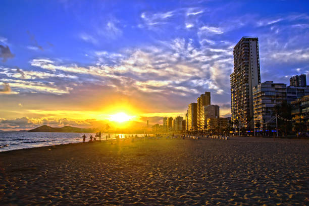 por do sol em platja de llevant em benidorm, spain - cloud sea beach umbrella sky - fotografias e filmes do acervo