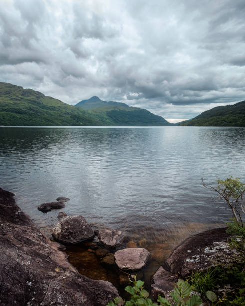 istock Scottish landscape with lake bank and mountains 1159227882