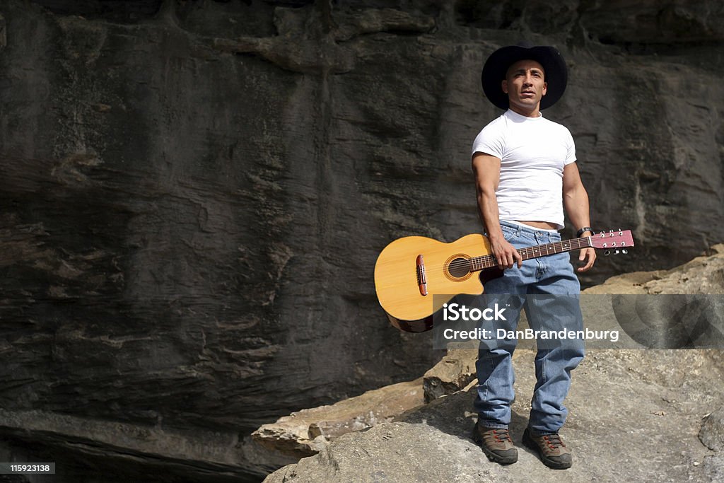Guitar Cowboy on a rock with his guitar Guitar Stock Photo