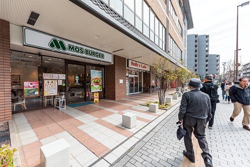 Kyoto, Japan - April 17, 2019: People walking near Nijo Station in morning by Mos Burger fast food restaurant wide angle view