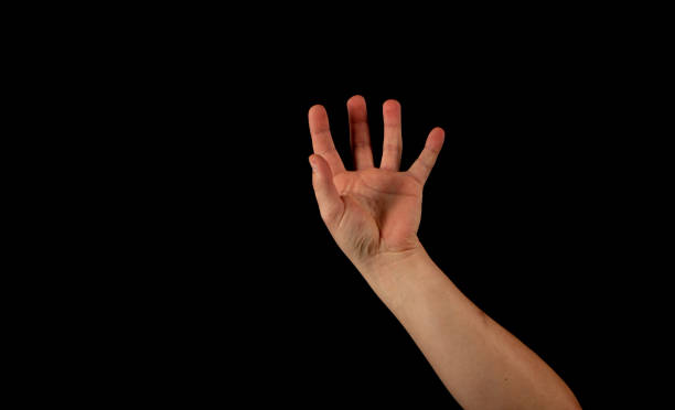istock The hand of a young man on a black background 1159231929