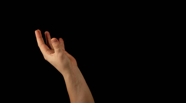istock The hand of a young man on a black background 1159231930