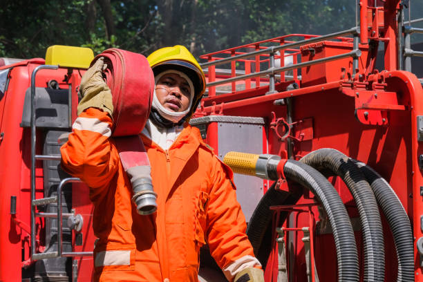 istock Firefighters training, Team practice to fighting with fire in emergency situation. A fireman carry a water hose run through flame 1159232078
