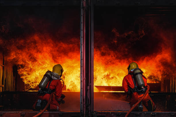 소방관 훈련, 비상 상황에서 화재와 싸우는 팀 연습. 밀폐된 장소에서 화염에 물을 뿌리다 - rubber band 뉴스 사진 이미지