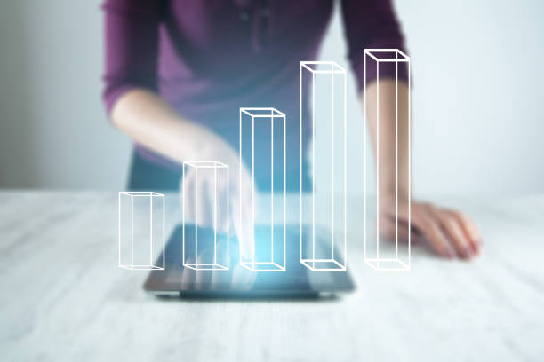 istock woman hand tablet with graph in screen on desk 1159236644